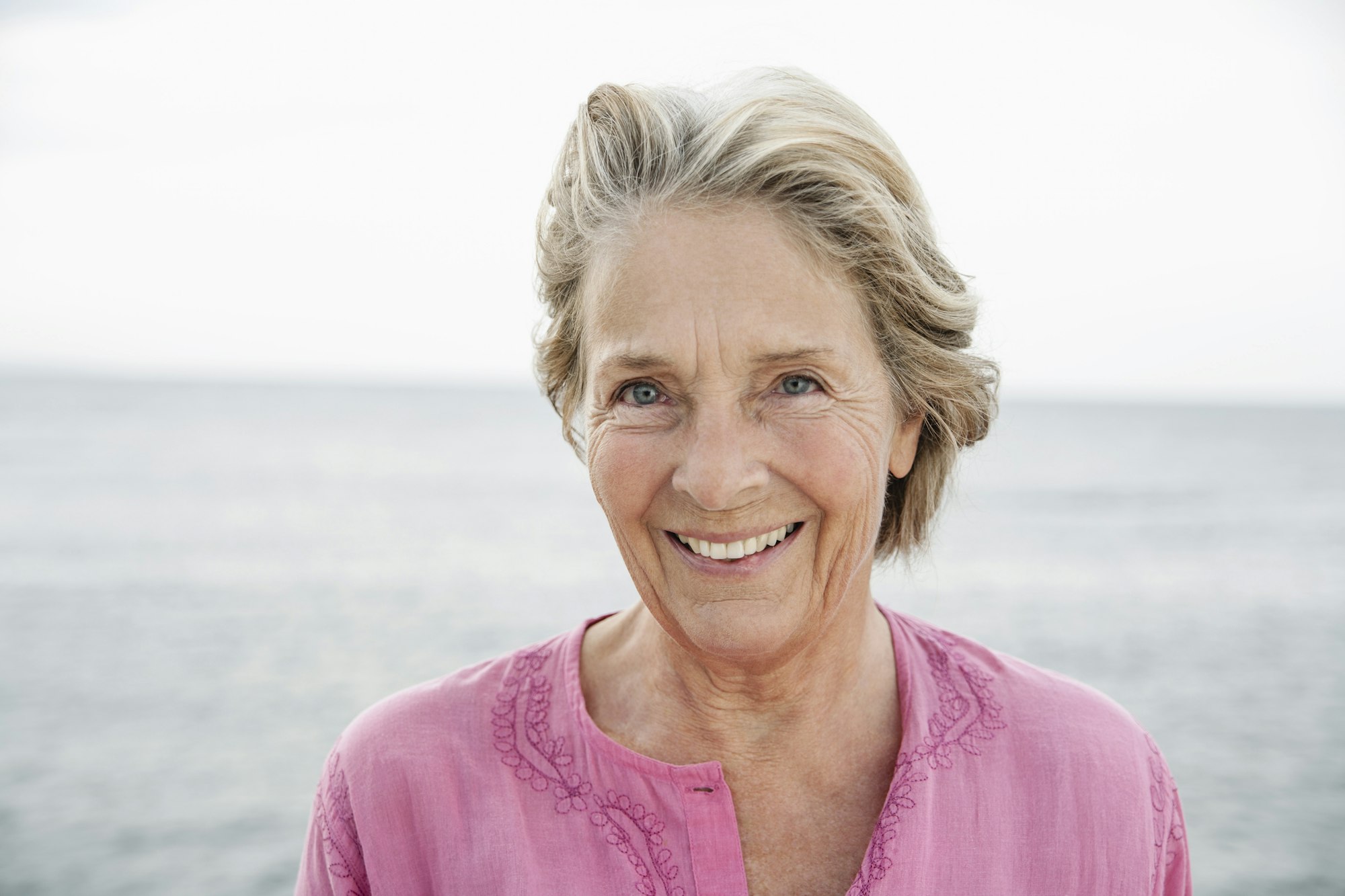 Spain, Senior woman smiling at Atlantic ocean